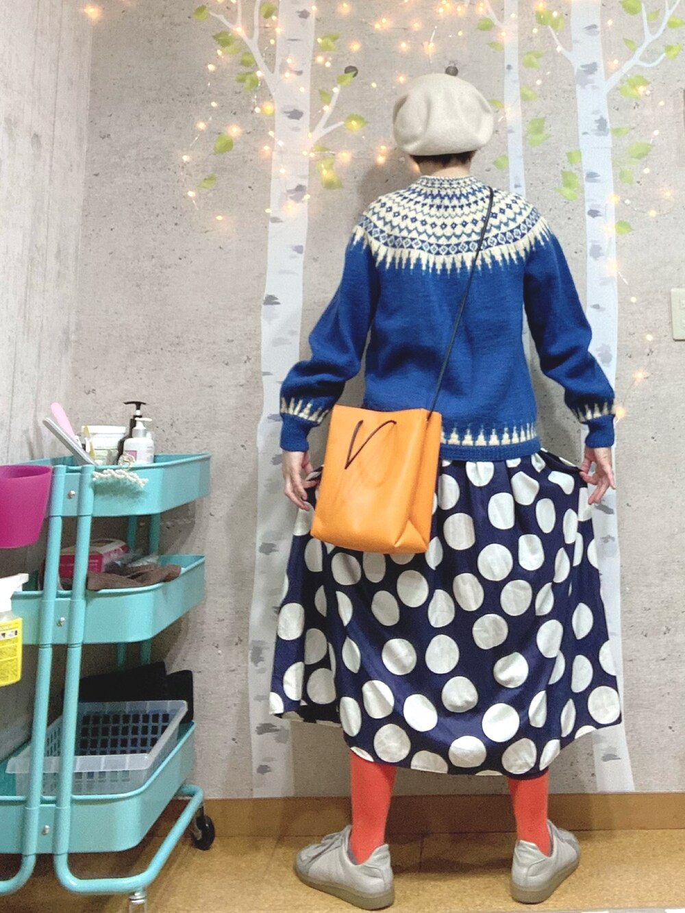 ブルー系のカーディガン/ボレロ、オレンジ系のショルダーバッグ、ブルー系のワンピースを着用したレディースの冬コーディネートの2枚目の写真