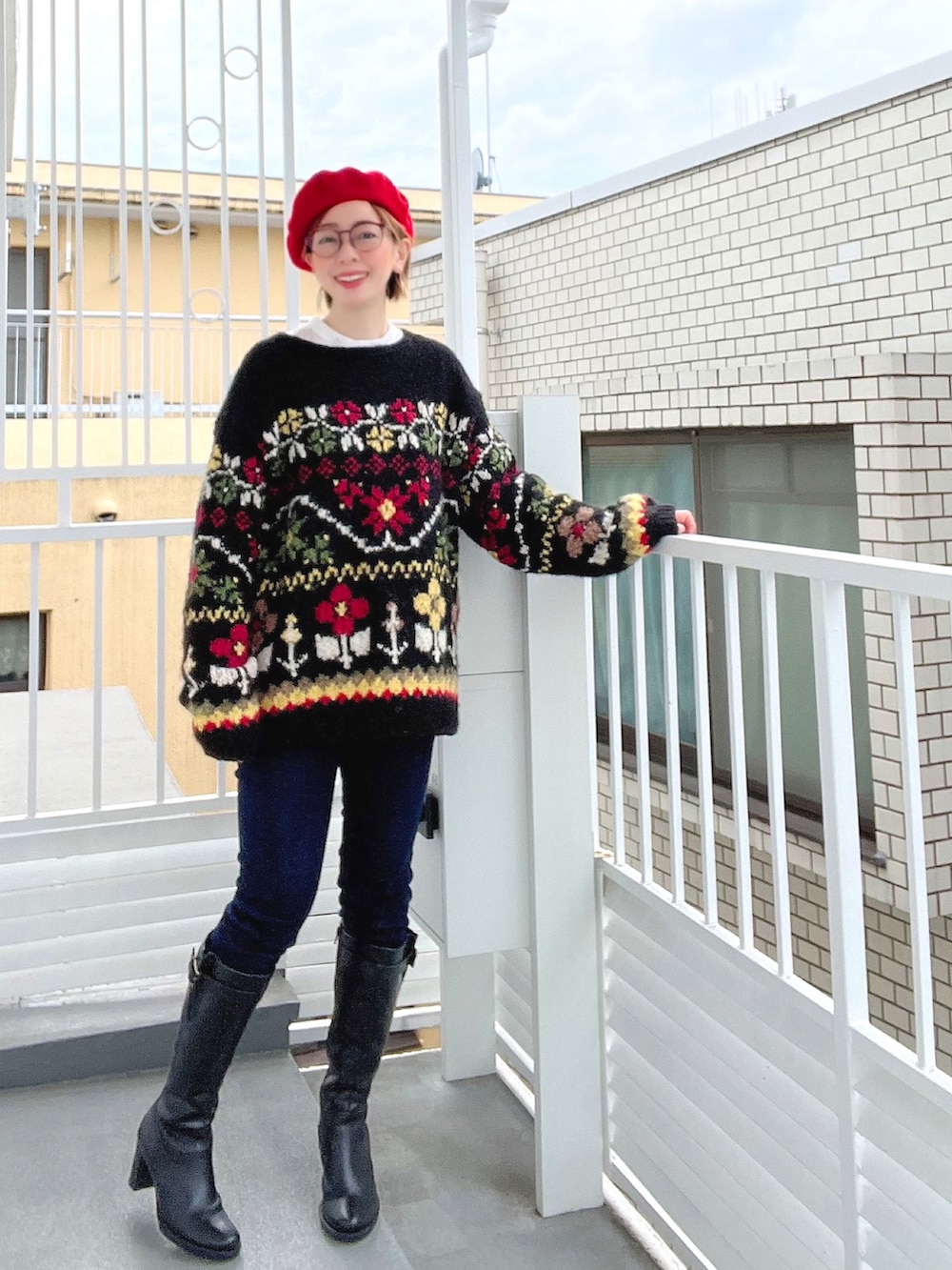 ブラウン系のポンチョ、ブラック系のニット/セーター、オレンジ系のショルダーバッグを着用したレディースの冬コーディネートの3枚目の写真