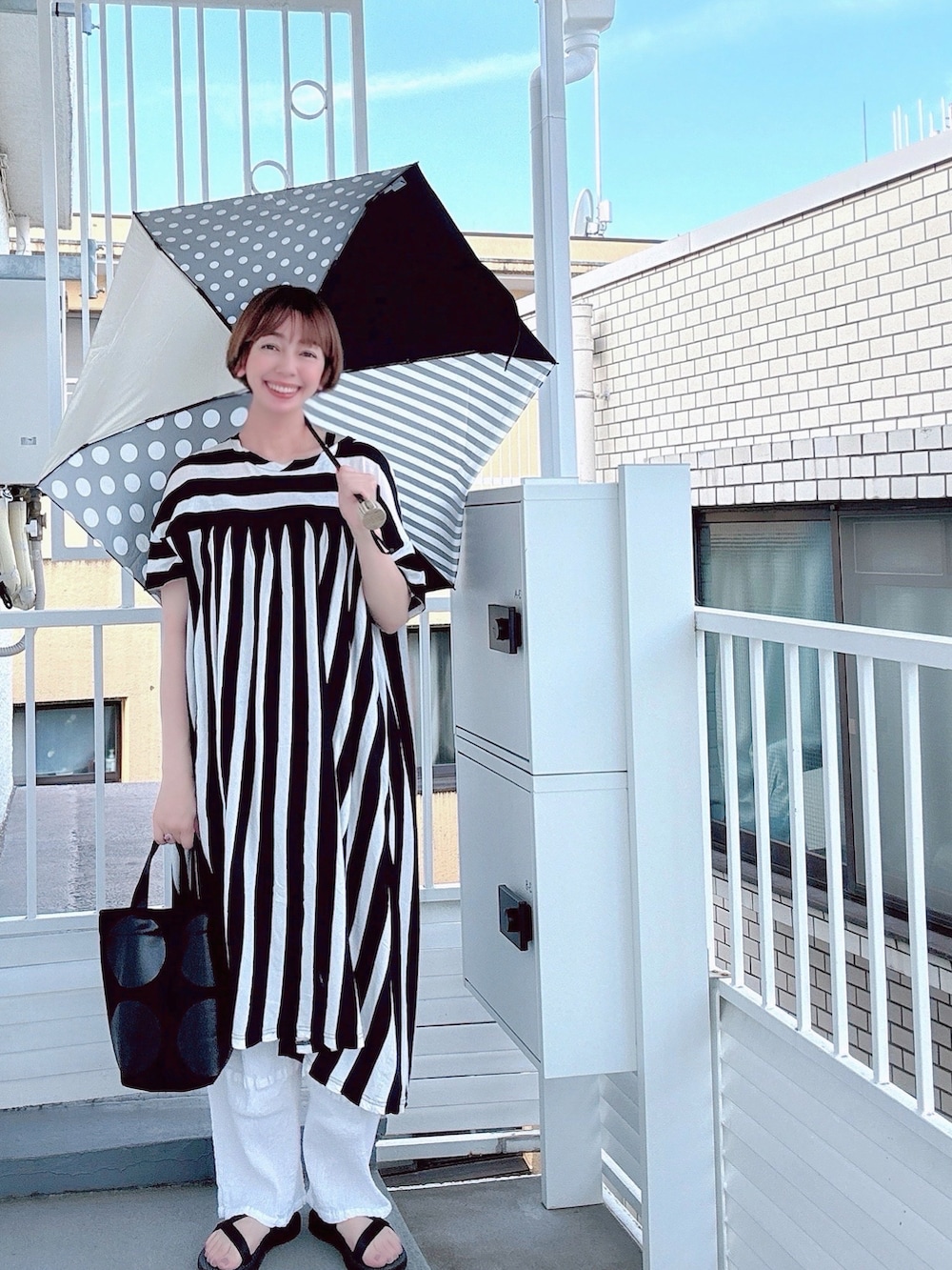 ブルー系のエコバッグ/サブバッグ、ブラック系のトートバッグ、その他の長傘を着用したレディースの秋コーディネートの2枚目の写真