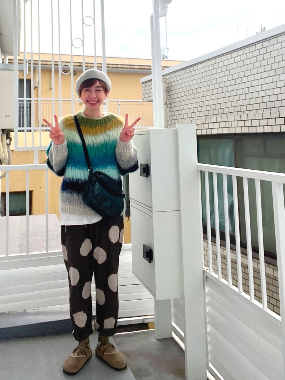 グリーン系のニット/セーター、グリーン系のショルダーバッグ、ブラウン系のその他パンツを着用したレディースの秋コーディネートの2枚目の写真