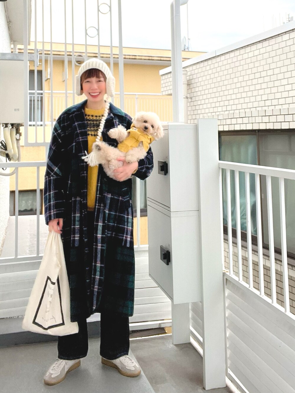 グリーン系のその他アウター、イエロー系のニット/セーター、ブルー系のデニムパンツを着用したレディースの春コーディネートの2枚目の写真