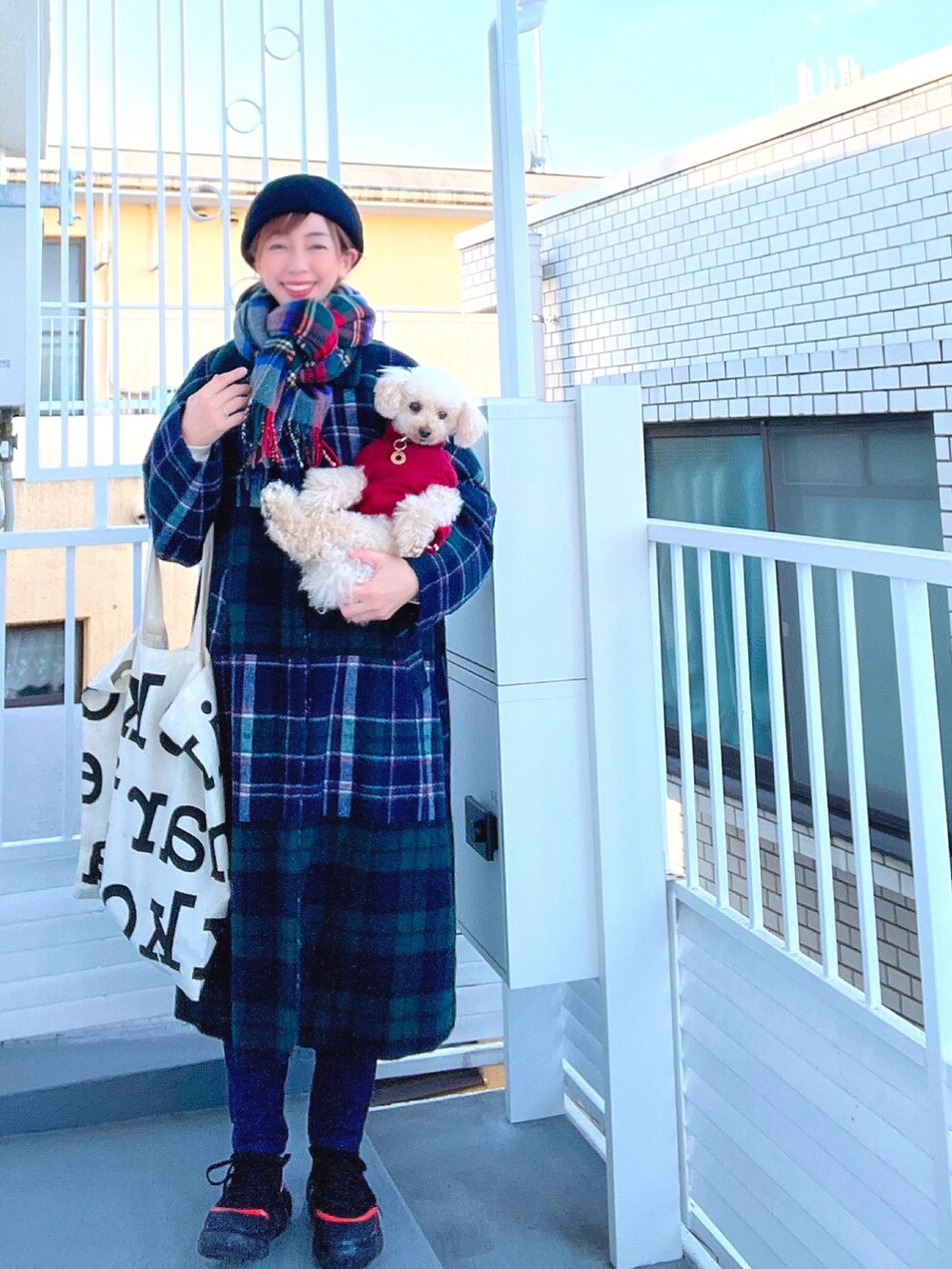 グリーン系のその他アウター、ホワイト系のトートバッグ、ブルー系のデニムパンツを着用したレディースの冬コーディネートの2枚目の写真