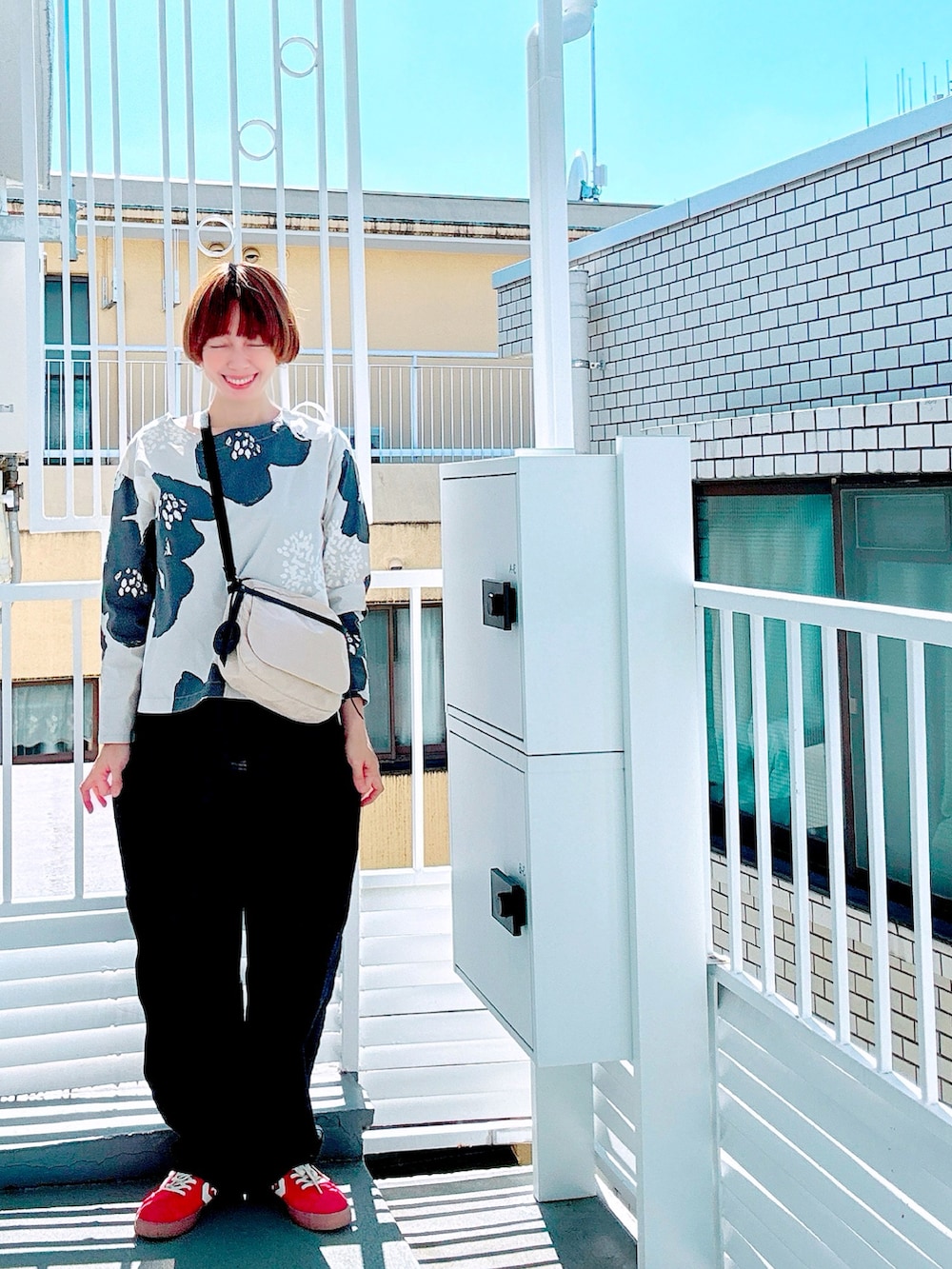 ホワイト系のシャツ/ブラウス、ブルー系のデニムパンツ、ホワイト系のスニーカーを着用したレディースの秋コーディネートの5枚目の写真