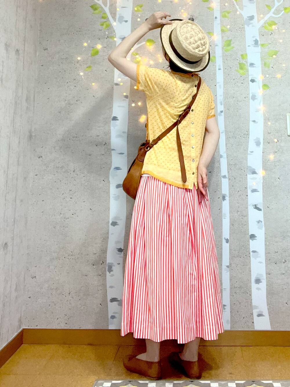 ブラウン系のショルダーバッグ、イエロー系のシャツ/ブラウス、レッド系のスカートを着用したレディースの春コーディネートの2枚目の写真