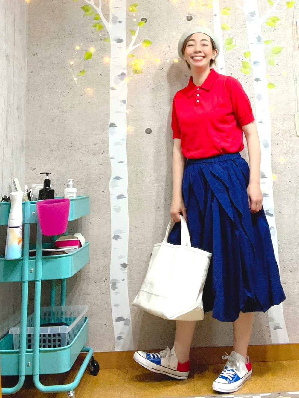 ホワイト系のトートバッグ、レッド系のポロシャツ、ブルー系のスカートを着用したレディースの夏コーディネートの2枚目の写真