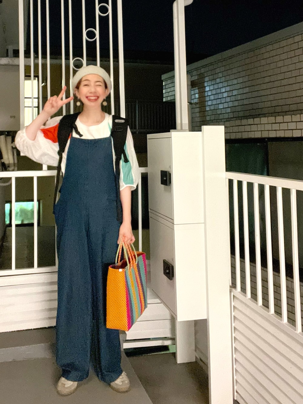 グレー系のTシャツ/カットソー、ブラウン系のかごバッグ、ブルー系のデニムパンツを着用したレディースの夏コーディネートの2枚目の写真