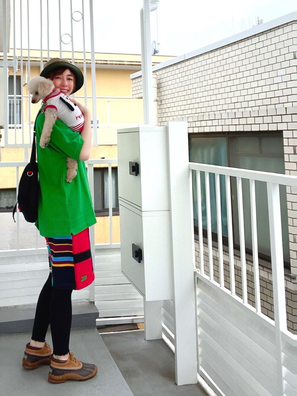 グリーン系のポロシャツ、ブラック系のショルダーバッグ、その他のその他パンツを着用したレディースの春コーディネートの2枚目の写真