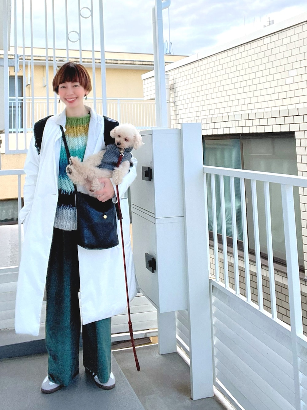 グリーン系のニット/セーター、グリーン系のパンツ、ホワイト系のスニーカーを着用したレディースの春コーディネートの3枚目の写真