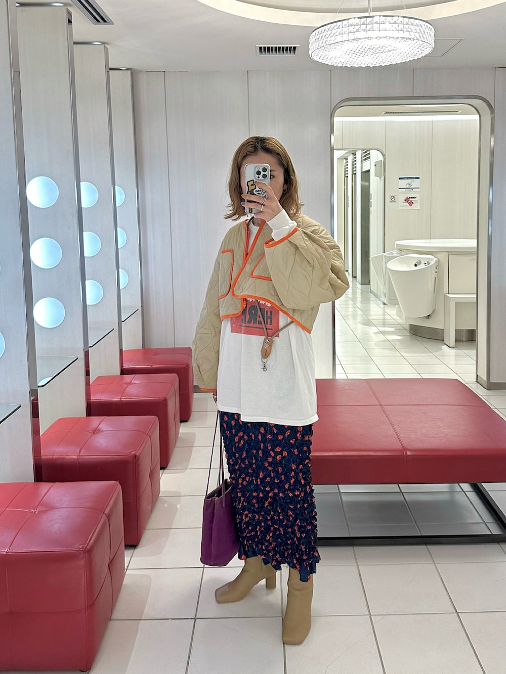 ベージュ系のノーカラージャケット、ホワイト系のTシャツ/カットソー、ブルー系のスカートを着用したレディースの冬コーディネートの2枚目の写真