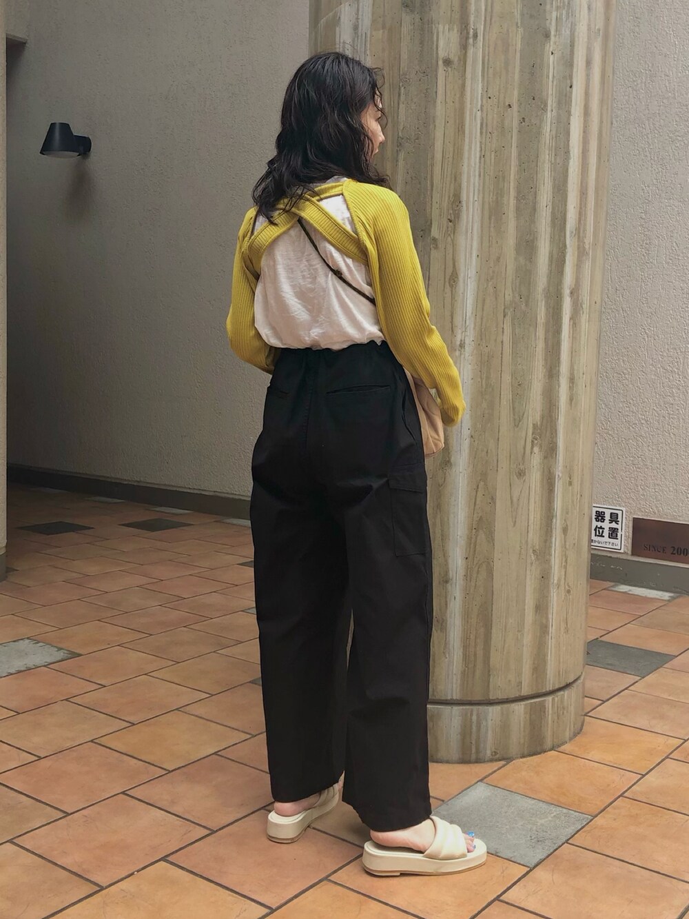イエロー系のカーディガン/ボレロ、ホワイト系のTシャツ/カットソー、ブラック系のその他パンツを着用したレディースの秋コーディネートの2枚目の写真