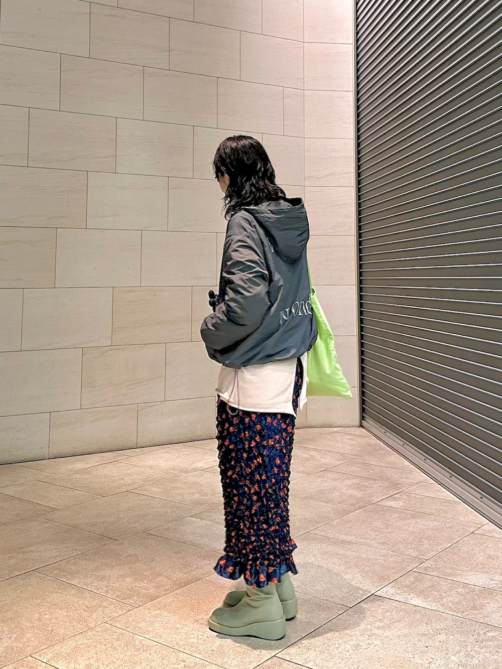 グレー系のパーカー、ピンク系のスウェット、ブルー系のスカートを着用したレディースの春コーディネートの2枚目の写真