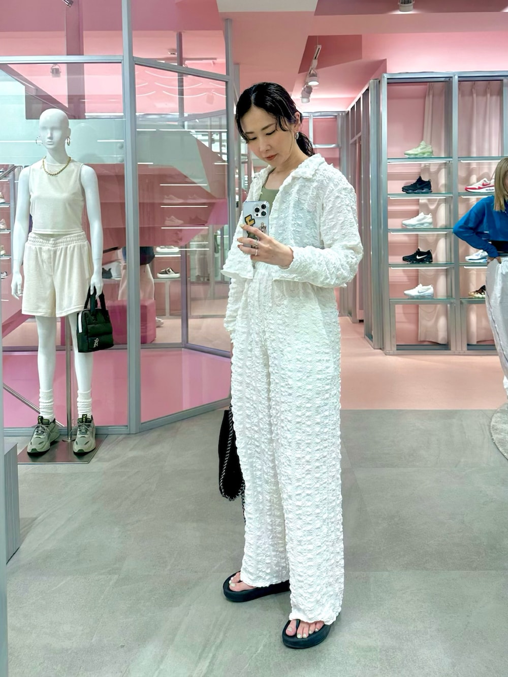 ホワイト系のシャツ/ブラウス、ホワイト系のその他パンツ、ブラック系のハンドバッグを着用したレディースの春コーディネートの2枚目の写真