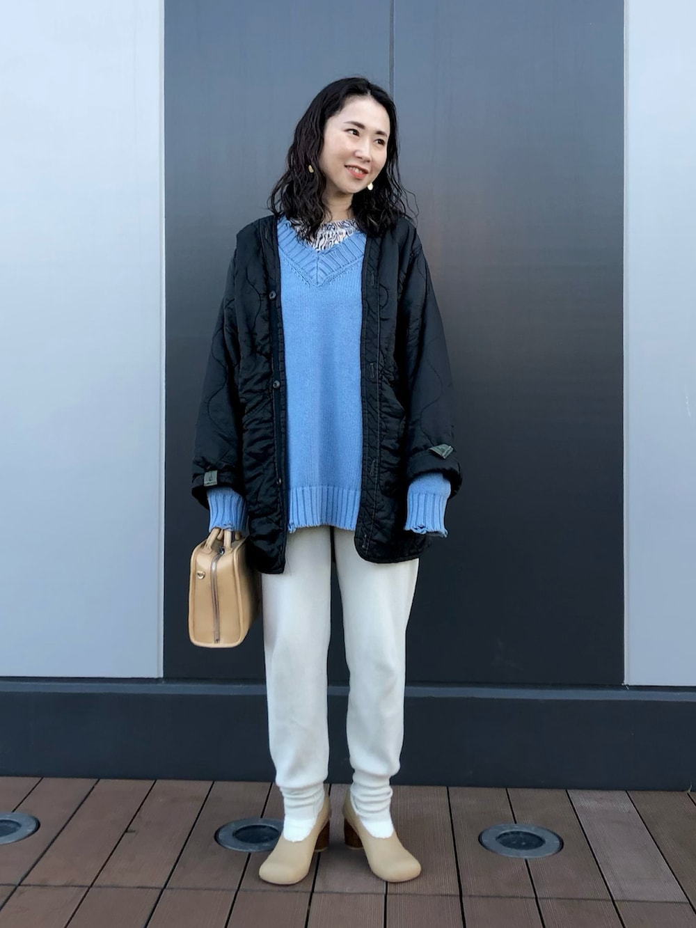 ブラック系のジャケット/アウター、ブルー系のニット/セーター、その他のTシャツ/カットソーを着用したレディースの冬コーディネートの2枚目の写真