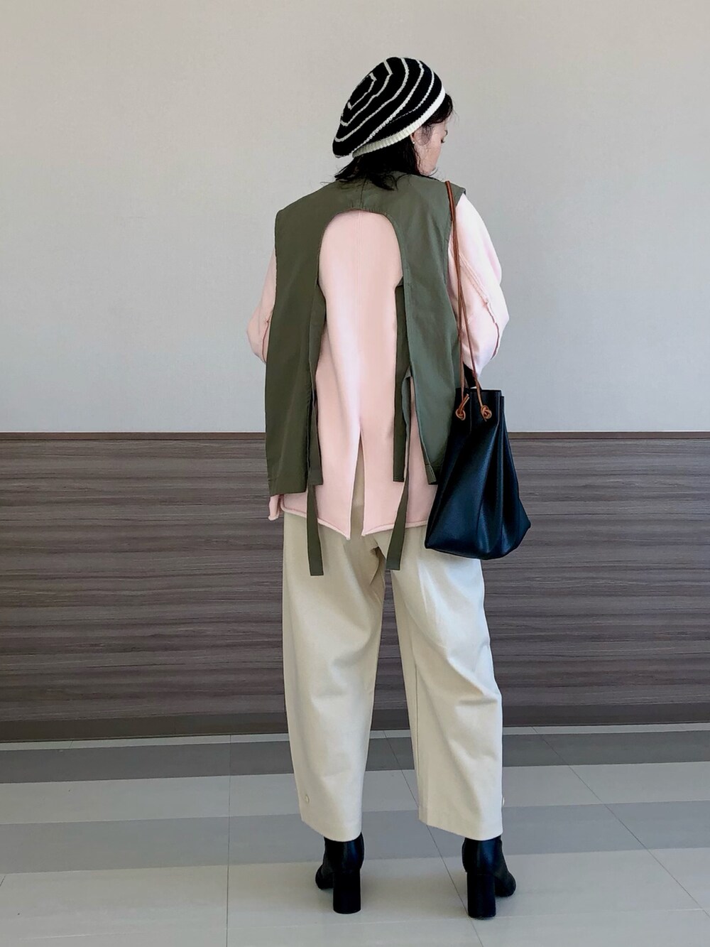 グリーン系のブルゾン、ピンク系のスウェット、ホワイト系のその他パンツを着用したレディースの冬コーディネートの3枚目の写真