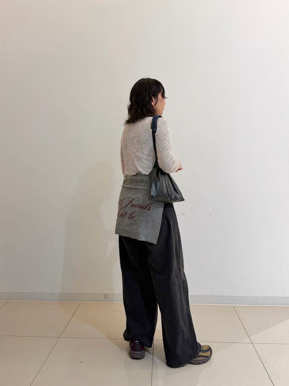グレー系のカーディガン/ボレロ、ブラック系のデニムパンツ、グリーン系のスニーカーを着用したレディースの春コーディネートの2枚目の写真