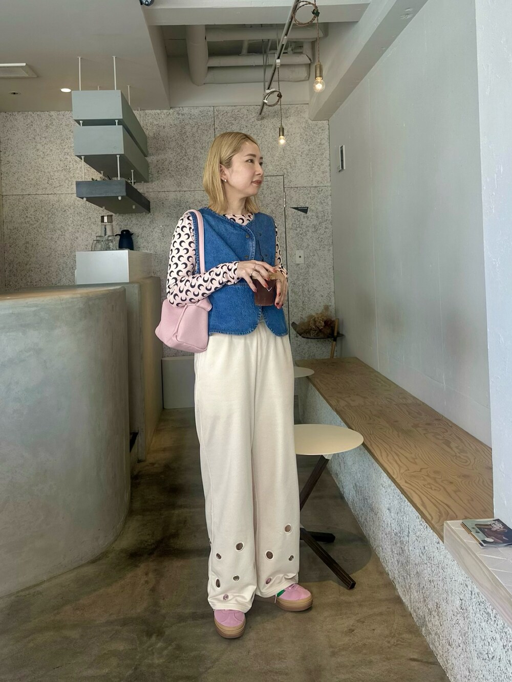 ブルー系のベスト、ベージュ系のTシャツ/カットソー、ホワイト系のスウェットパンツを着用したレディースの春コーディネートの2枚目の写真