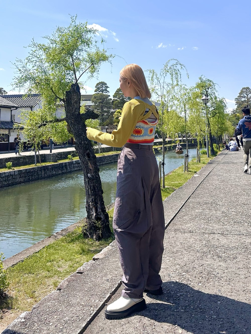 イエロー系のカーディガン/ボレロ、レッド系のニット/セーター、ブルー系のTシャツ/カットソーを着用したレディースの春コーディネートの2枚目の写真