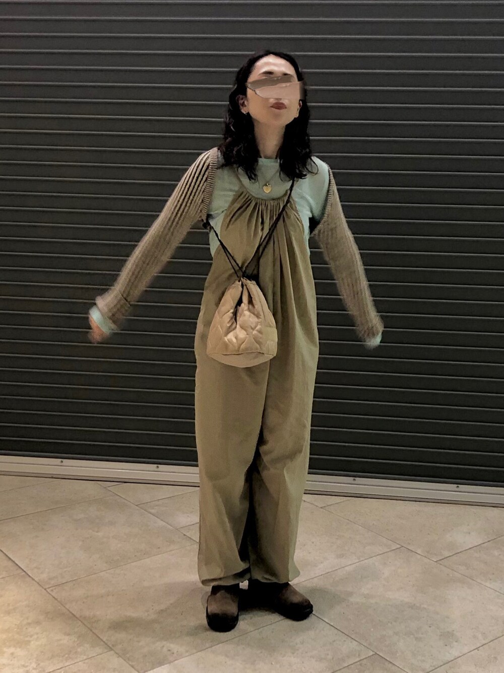 ブラウン系のニット/セーター、ベージュ系のサロペット/オーバーオール、ブルー系のTシャツ/カットソーを着用したレディースの秋コーディネートの2枚目の写真