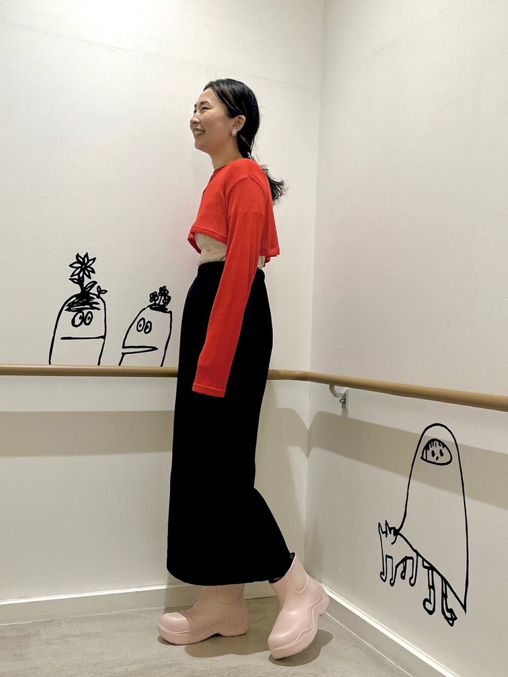 レッド系のTシャツ/カットソー、ピンク系のTシャツ/カットソー、ブルー系のスカートを着用したレディースの春コーディネートの2枚目の写真