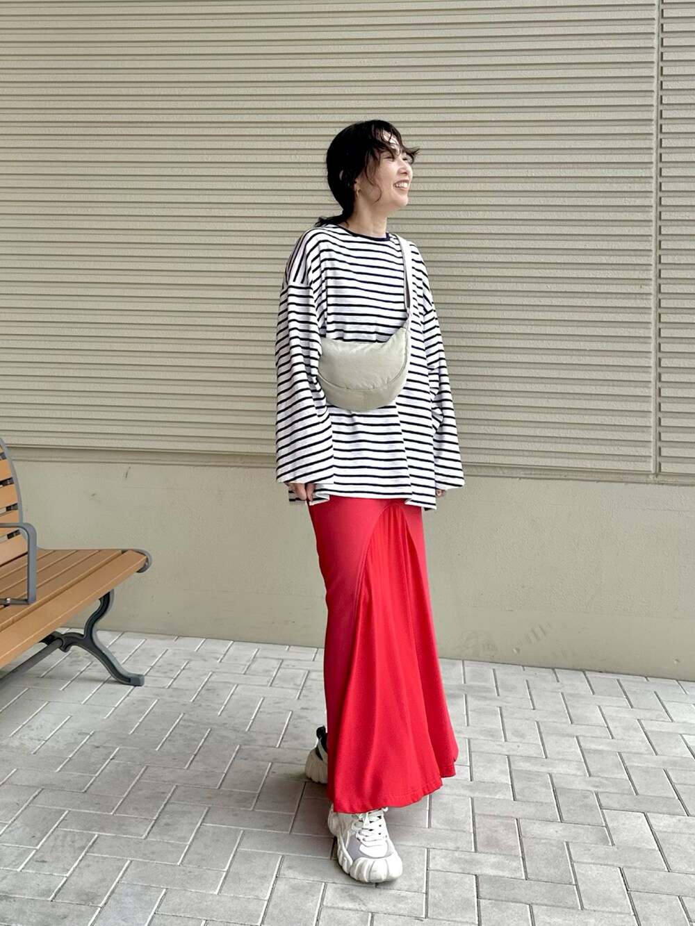 ブルー系のTシャツ/カットソー、レッド系のスカート、ホワイト系のショルダーバッグを着用したレディースの春コーディネートの2枚目の写真