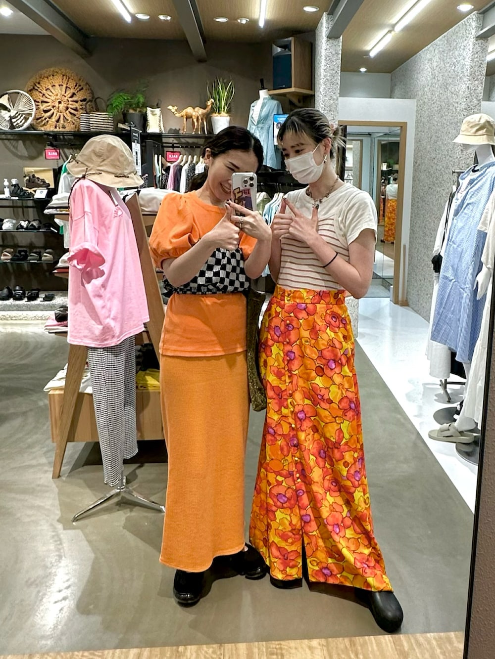 オレンジ系のTシャツ/カットソー、ブラック系のその他トップス、オレンジ系のスカートを着用したレディースの夏コーディネートの2枚目の写真