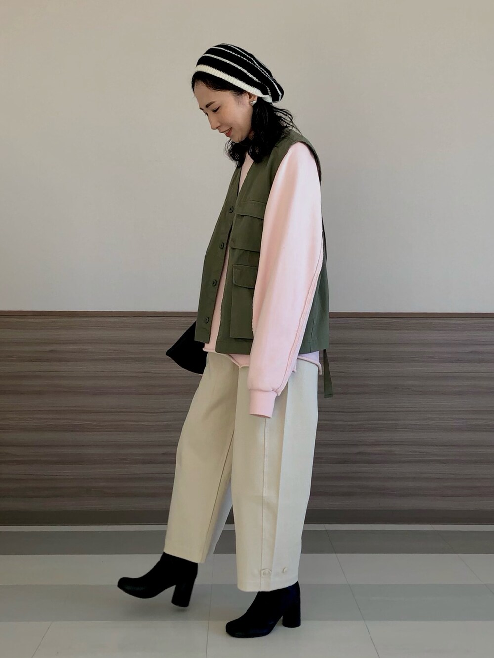 グリーン系のブルゾン、ピンク系のスウェット、ホワイト系のその他パンツを着用したレディースの冬コーディネートの2枚目の写真