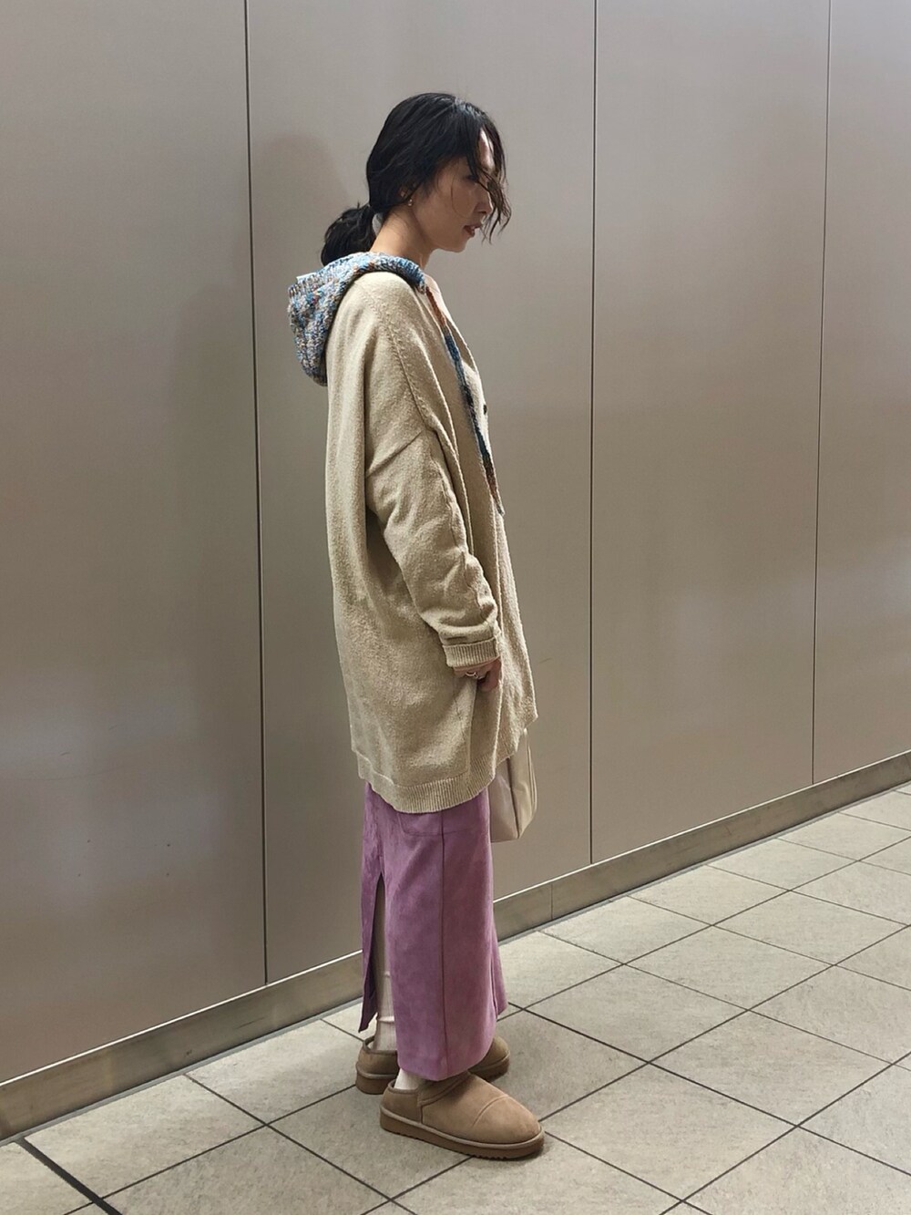 ベージュ系のカーディガン/ボレロ、ピンク系のトップス、パープル系のスカートを着用したレディースの冬コーディネートの2枚目の写真