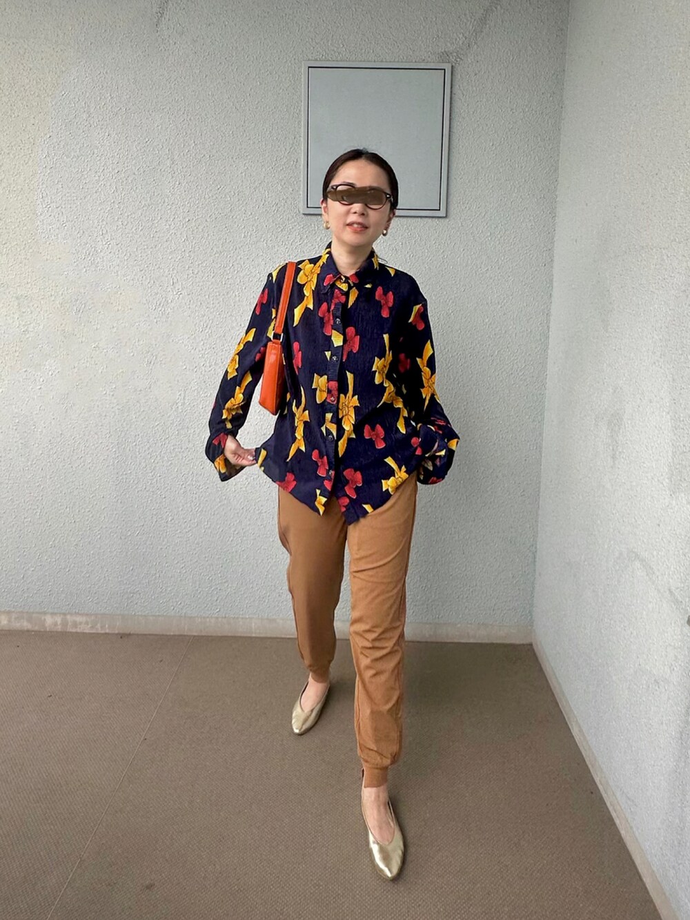 ブルー系のシャツ/ブラウス、ブラウン系のその他パンツ、オレンジ系のハンドバッグを着用したレディースの秋コーディネートの2枚目の写真