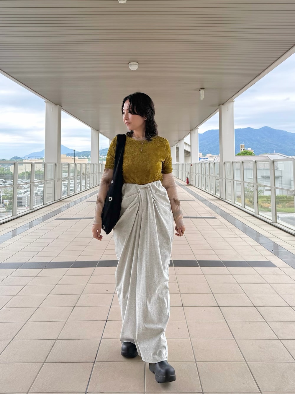 グリーン系のTシャツ/カットソー、グレー系のその他パンツ、ブラック系のトートバッグを着用したレディースの夏コーディネートの2枚目の写真