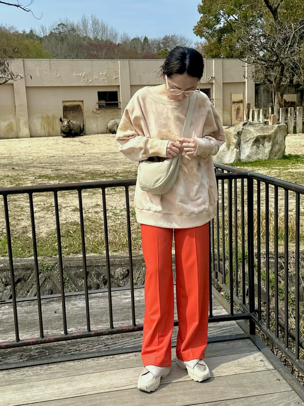 ピンク系のTシャツ/カットソー、レッド系のその他パンツ、ホワイト系のショルダーバッグを着用したレディースの春コーディネートの2枚目の写真