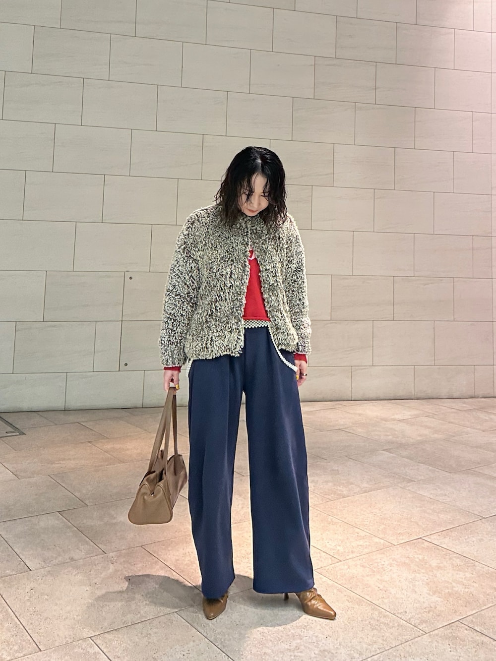 ブラウン系のノーカラージャケット、ブルー系のスウェットパンツ、イエロー系のブーツを着用したレディースの冬コーディネートの2枚目の写真