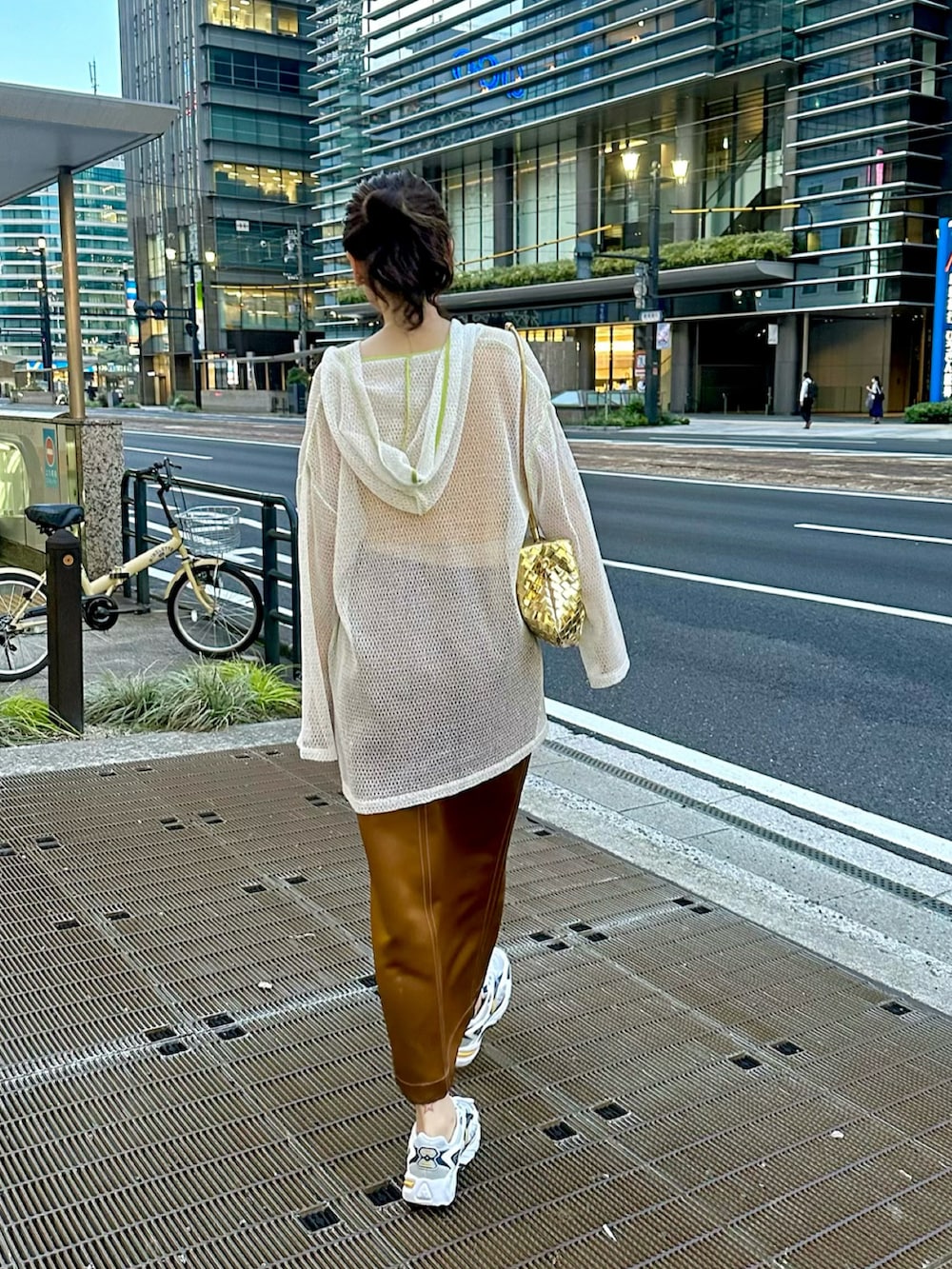 ホワイト系のパーカー、イエロー系のTシャツ/カットソー、ベージュ系のスカートを着用したレディースの夏コーディネートの3枚目の写真