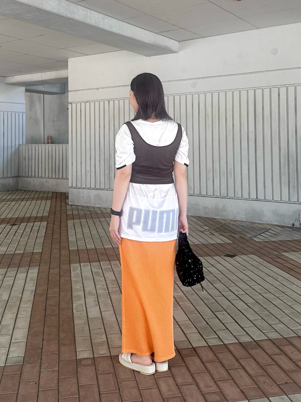 ホワイト系のTシャツ/カットソー、ブラウン系のタンクトップ、オレンジ系のスカートを着用したレディースの夏コーディネートの2枚目の写真