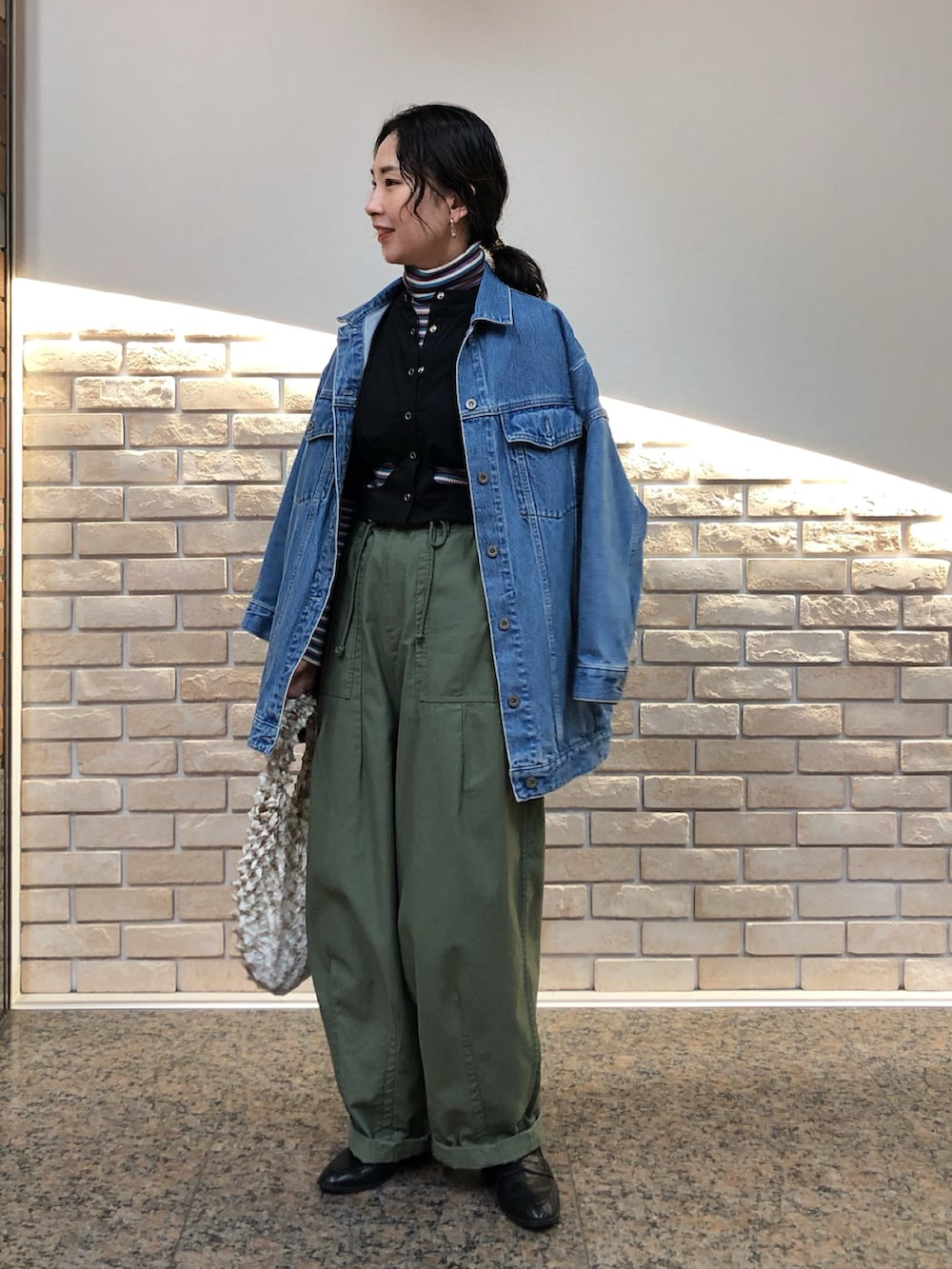 ブルー系のデニムジャケット、ブラック系のシャツ/ブラウス、パープル系のニット/セーターを着用したレディースの冬コーディネートの3枚目の写真