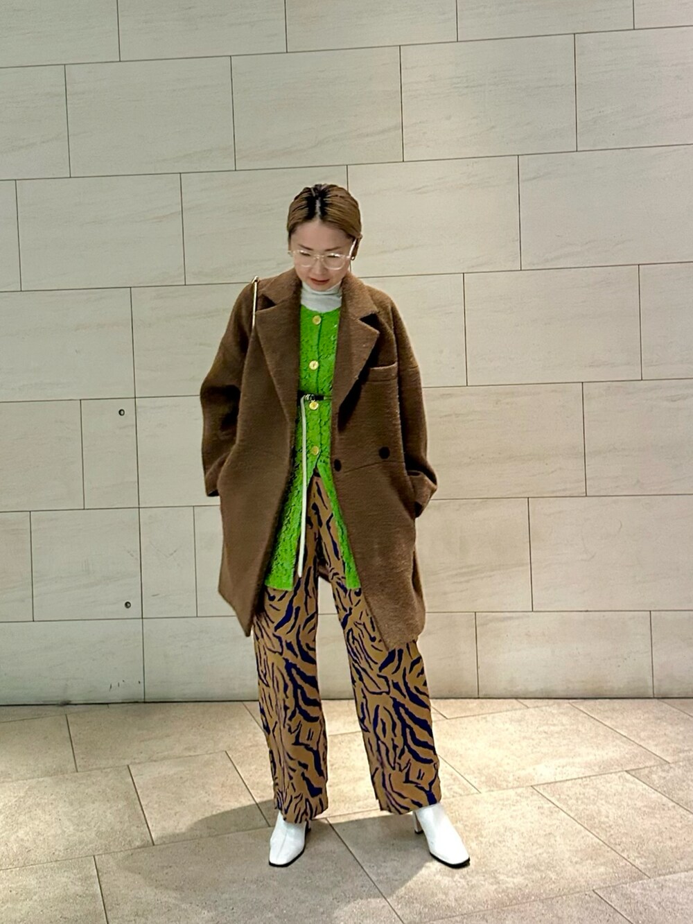 ベージュ系のその他アウター、グリーン系のカーディガン/ボレロ、オレンジ系のその他パンツを着用したレディースの冬コーディネートの2枚目の写真