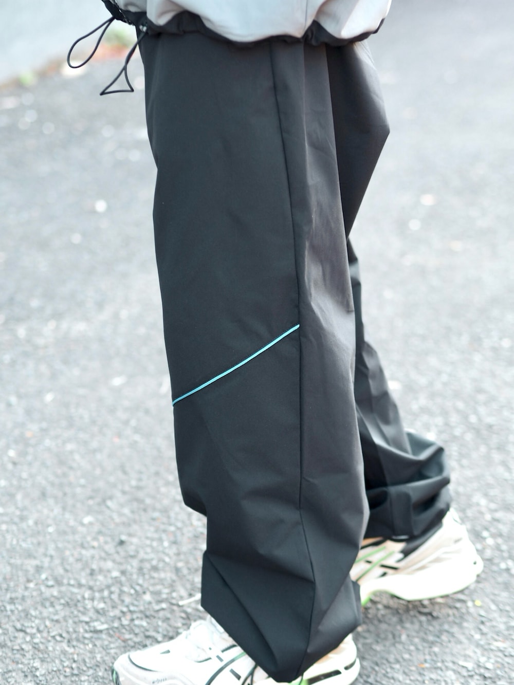 ブラック系のマウンテンパーカー、ブラック系のその他パンツ、ベージュ系のスニーカーを着用したメンズの冬コーディネートの3枚目の写真