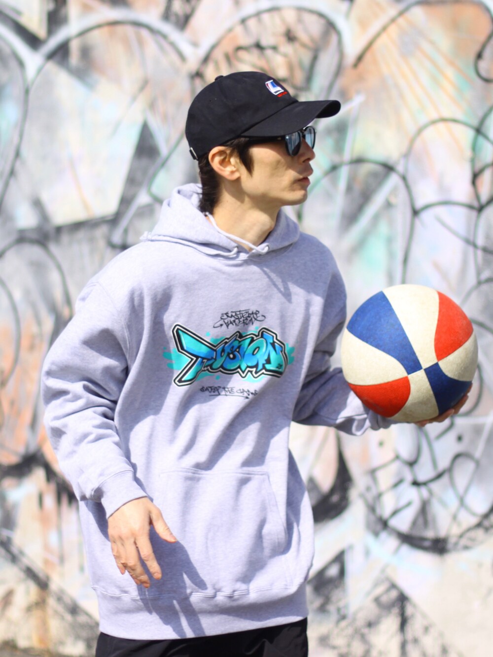 グレー系のパーカー、ホワイト系のスニーカー、ブラック系のその他パンツを着用したメンズの春コーディネートの2枚目の写真