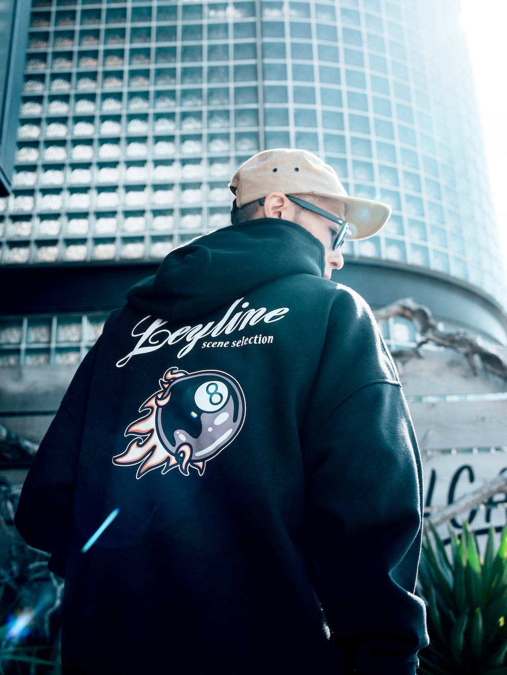 ブラック系のパーカー、ベージュ系のスニーカー、ベージュ系のキャップを着用したメンズの春コーディネートの3枚目の写真