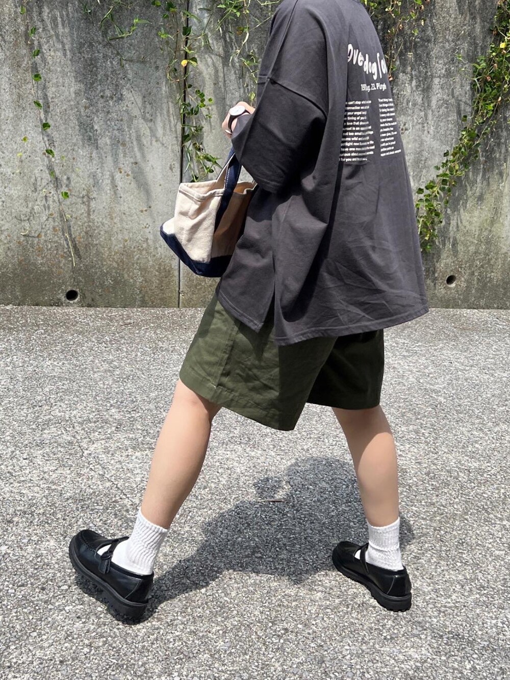 グレー系のTシャツ/カットソー、ブルー系のトートバッグ、ブラック系のローファーを着用したレディースの夏コーディネートの3枚目の写真