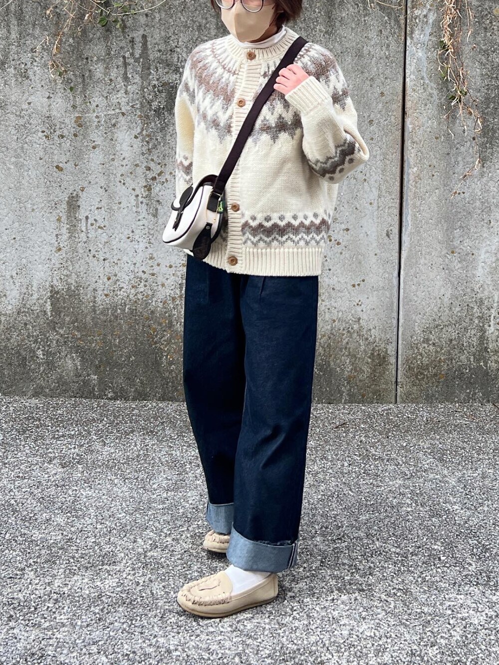 ブルー系のデニムパンツ、ホワイト系のショルダーバッグ、ベージュ系のその他シューズを着用したレディースの冬コーディネートの2枚目の写真