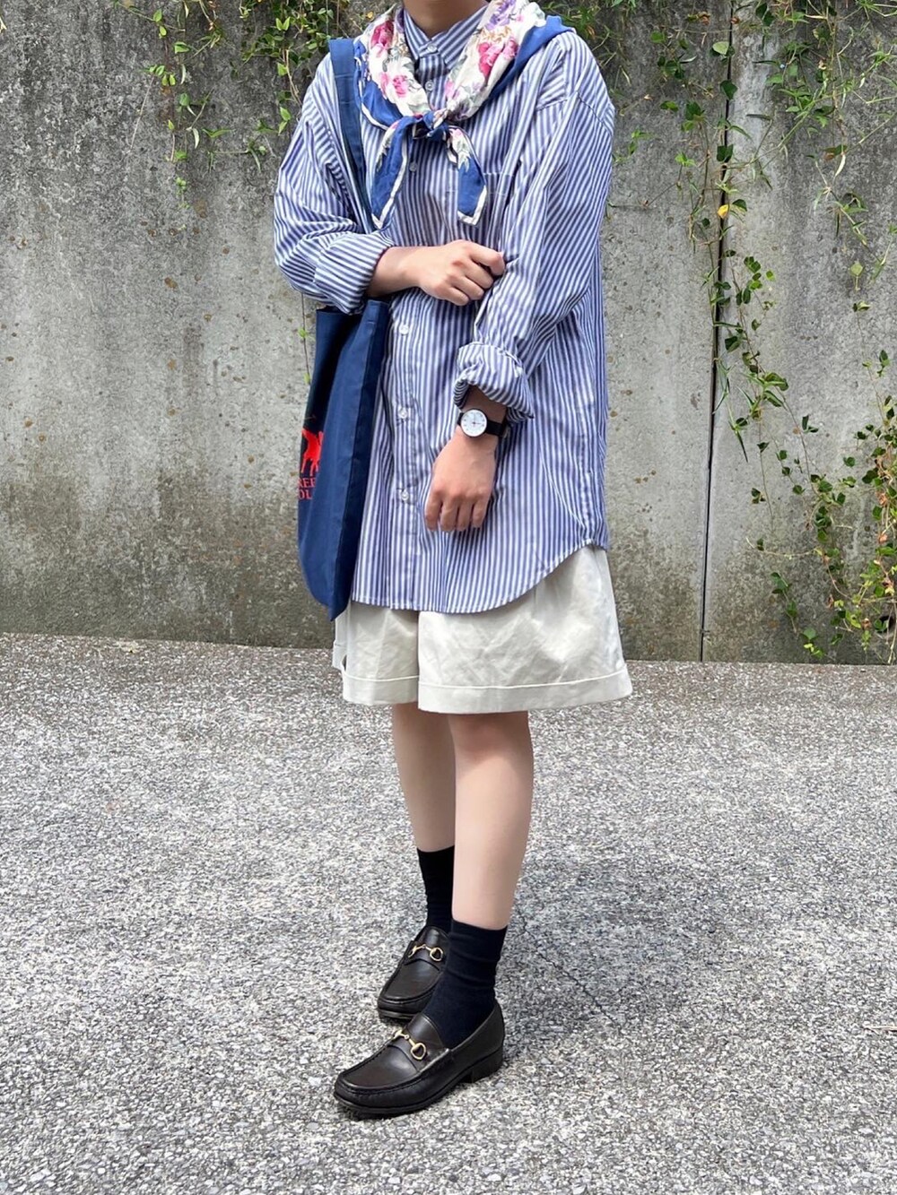 ベージュ系のパンツ、ブルー系のトートバッグを着用したレディースの夏コーディネートの3枚目の写真