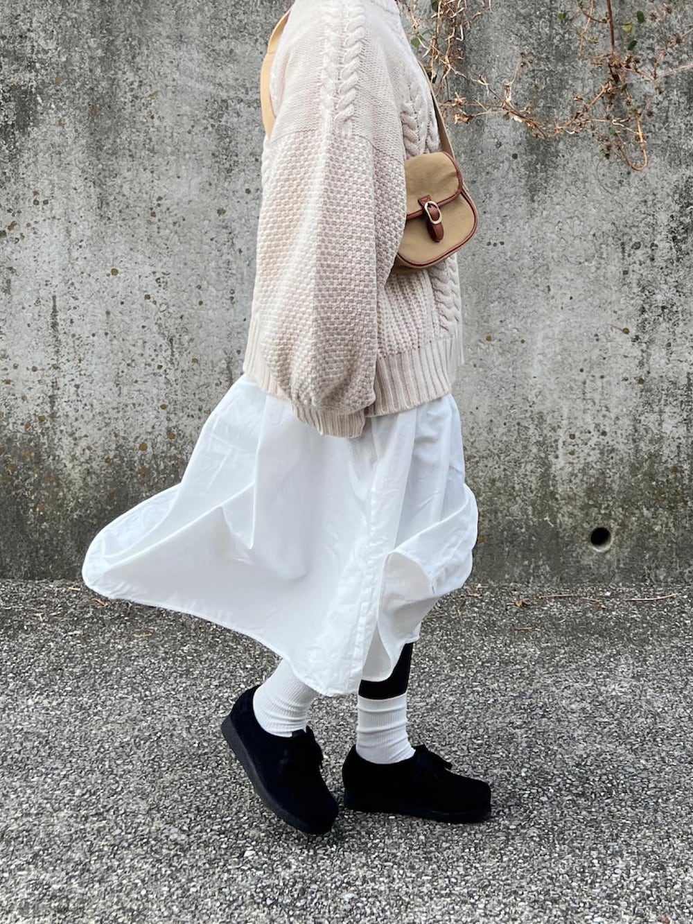 グリーン系のミリタリージャケット、ホワイト系のニット/セーター、ベージュ系のショルダーバッグを着用したレディースの冬コーディネートの4枚目の写真