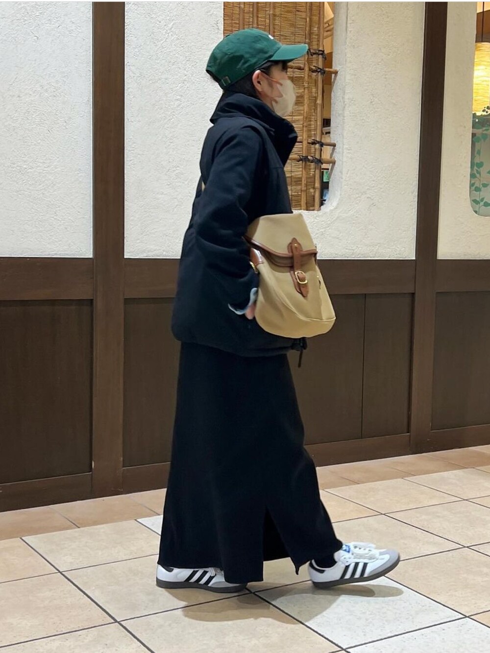 グリーン系のショルダーバッグ、ブラック系のベスト、ブルー系のシャツ/ブラウスを着用したレディースの冬コーディネートの2枚目の写真