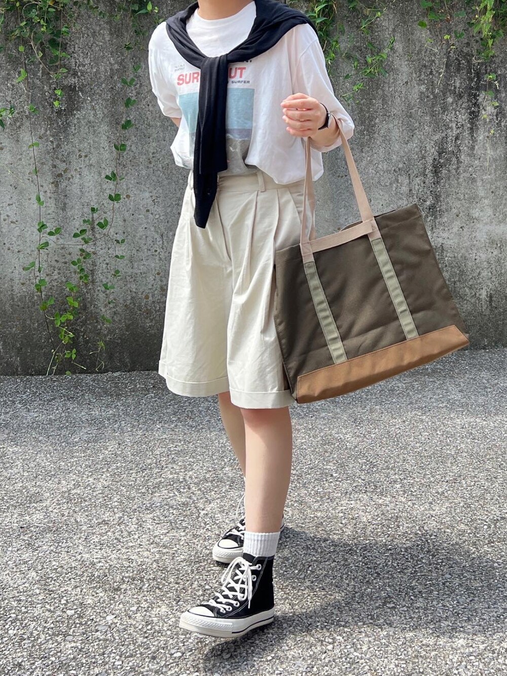 ホワイト系のTシャツ/カットソー、ベージュ系のパンツ、ブラック系のスニーカーを着用したレディースの秋コーディネートの2枚目の写真