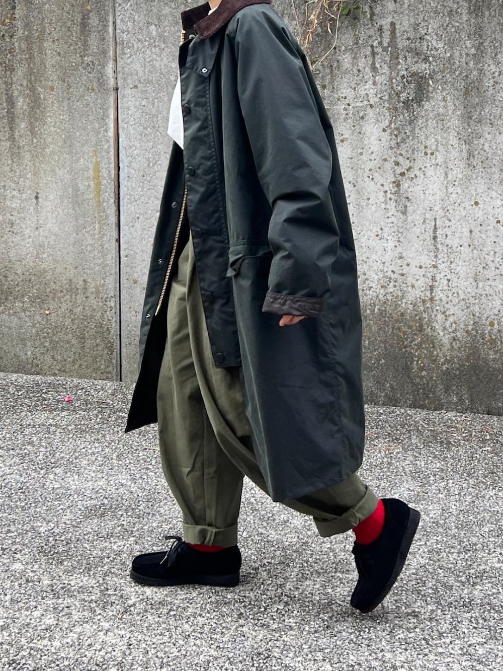 グリーン系のトートバッグ、ブラック系のモカシン/デッキシューズ、グリーン系のステンカラーコートを着用したレディースの冬コーディネートの2枚目の写真