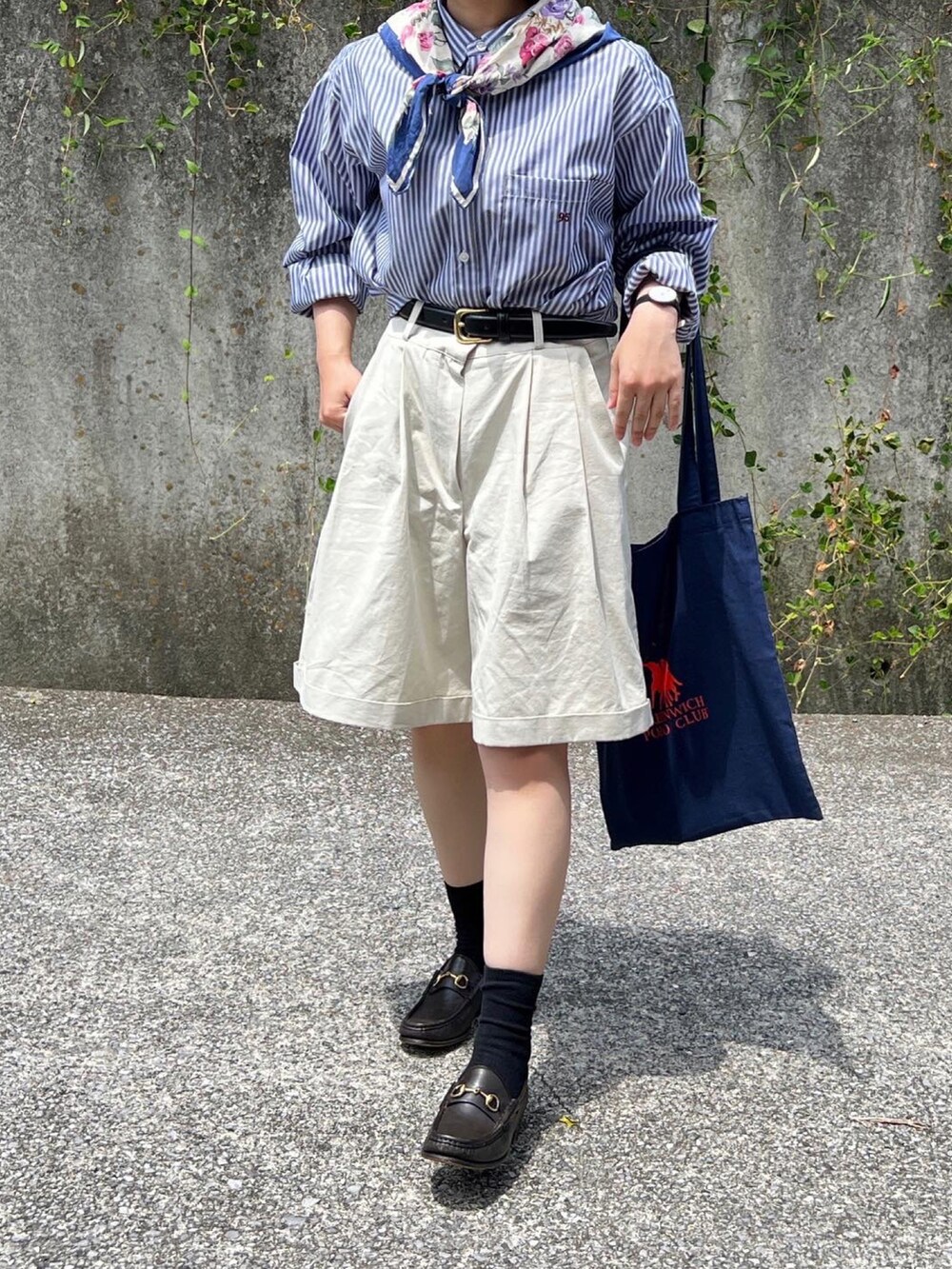 ベージュ系のパンツ、ブルー系のトートバッグを着用したレディースの夏コーディネートの2枚目の写真