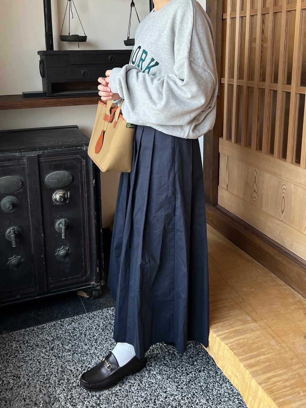 グリーン系のトートバッグを着用したレディースの秋コーディネートの3枚目の写真