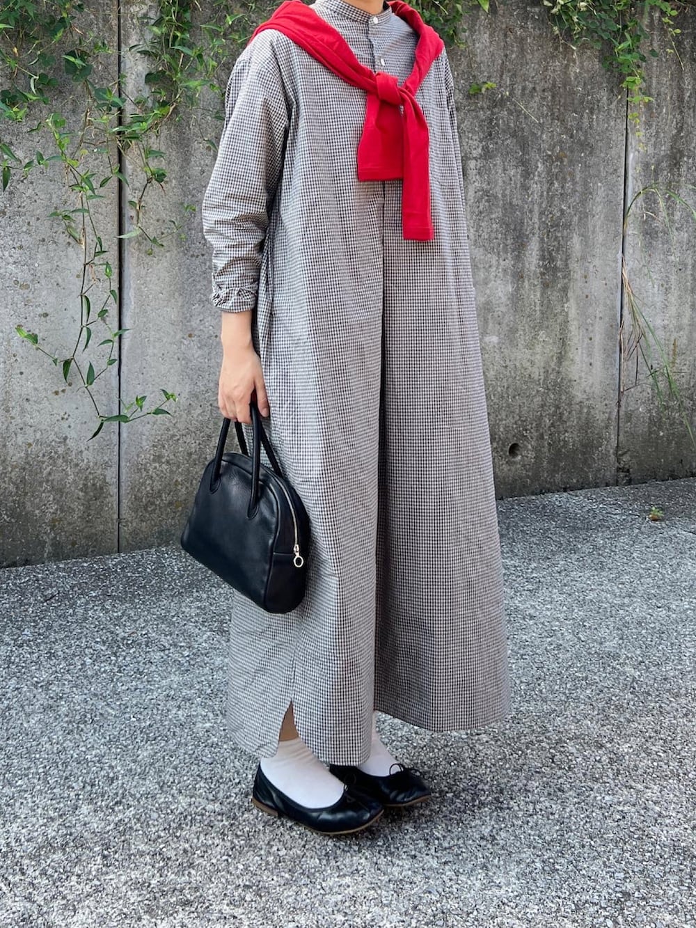 ブラック系のシャツワンピース、ブラック系のバッグ、ブラック系のバレエシューズを着用したレディースの秋コーディネートの2枚目の写真