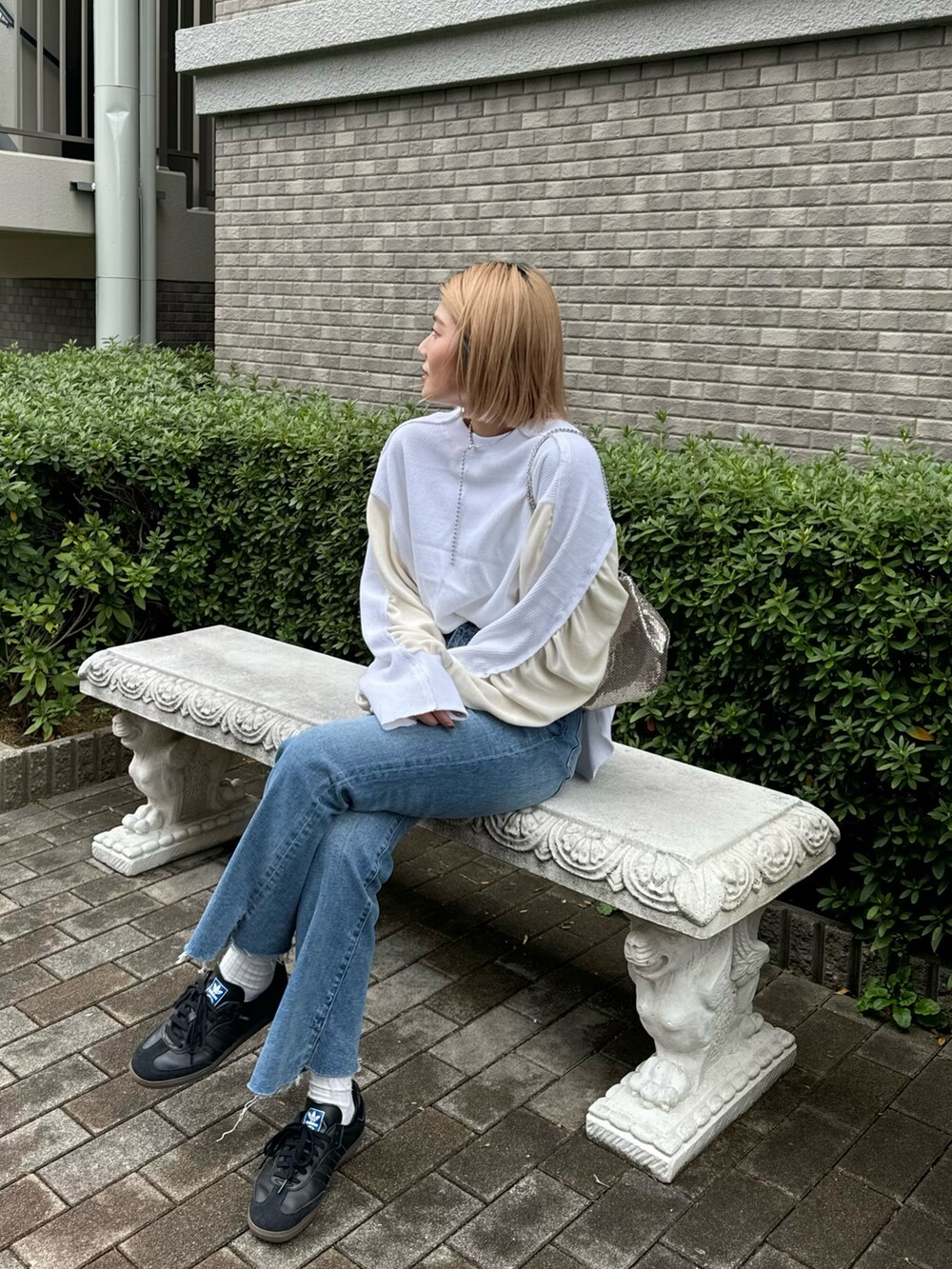 ホワイト系のTシャツ/カットソー、ブルー系のデニムパンツ、ブラック系のスニーカーを着用したレディースの冬コーディネートの4枚目の写真