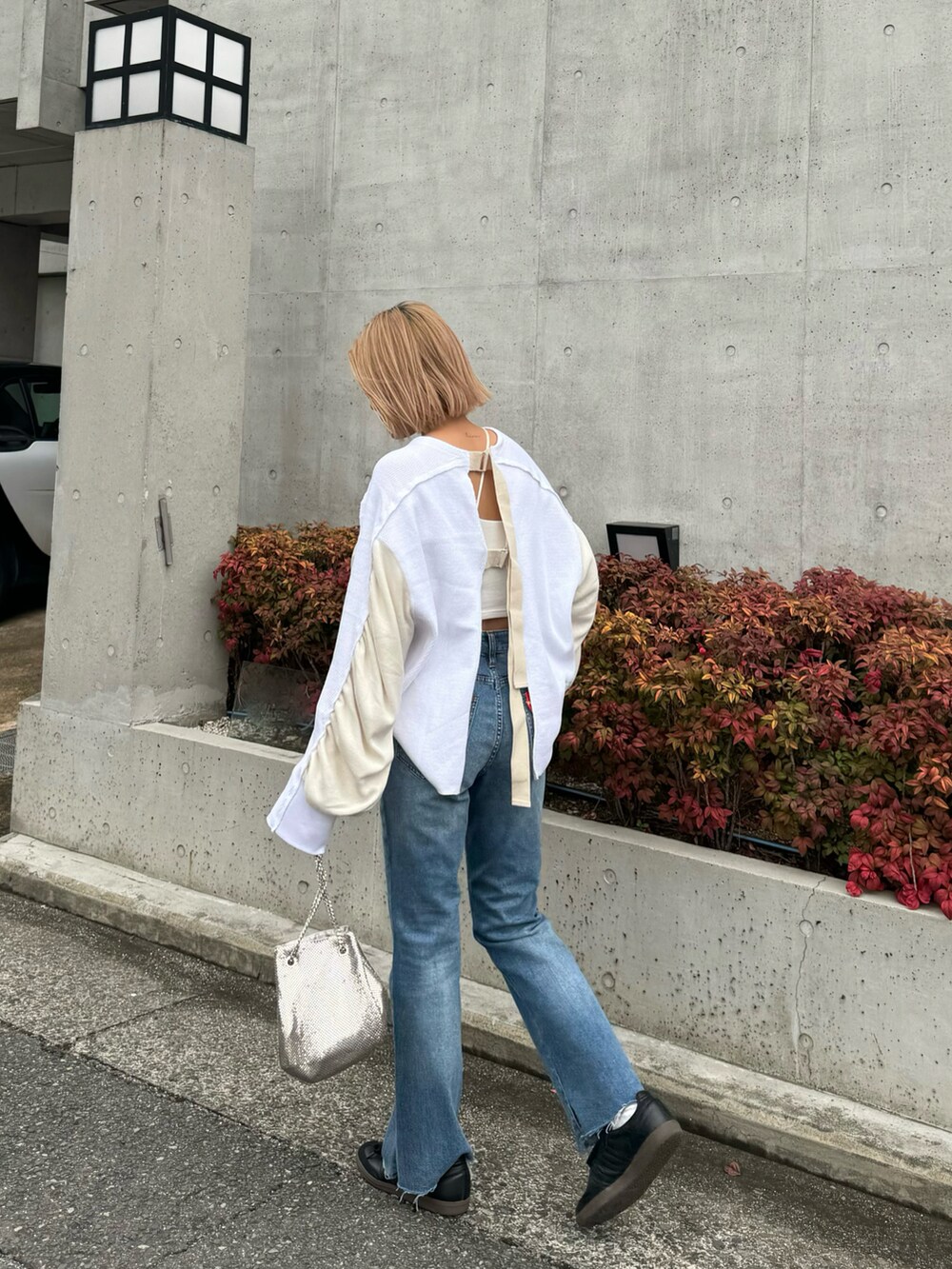 ホワイト系のTシャツ/カットソー、ブルー系のデニムパンツ、ブラック系のスニーカーを着用したレディースの冬コーディネートの3枚目の写真